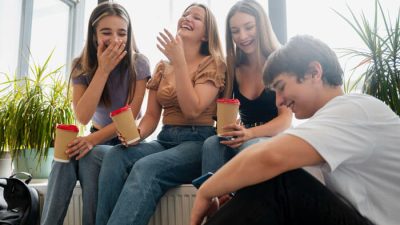 Friends laughing together while sharing jokes, showing what are some good roasts that can make conversations fun and lighthearted.