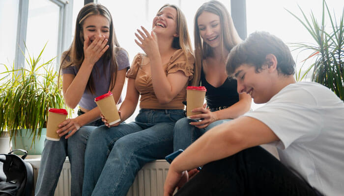 Friends laughing together while sharing jokes, showing what are some good roasts that can make conversations fun and lighthearted.