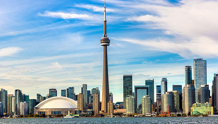 Toronto skyline with the CN Tower and Rogers Centre viewed from Lake Ontario — one of the best places to visit in Canada for culture, food, and stunning city views.