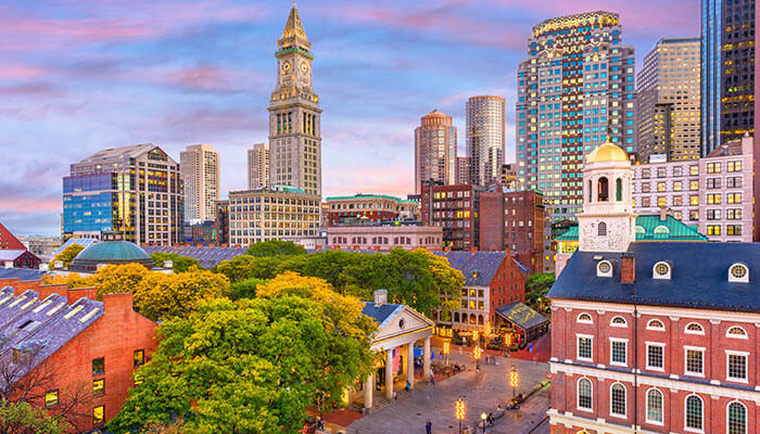 Downtown Boston skyline at sunset with historic Faneuil Hall and modern skyscrapers