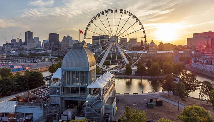 Montreal Old Port with La Grande Roue Ferris Wheel and historic buildings during sunset — a vibrant cultural spot in Quebec.