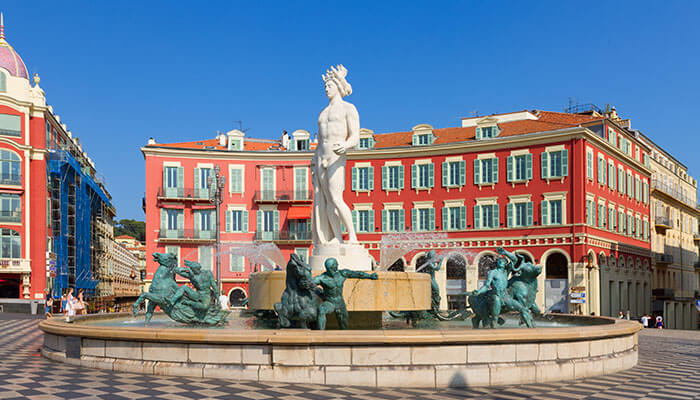 Fountain of Apollo at Place Massena in Nice surrounded by colorful architecture, a must-see on a south of France vacation.