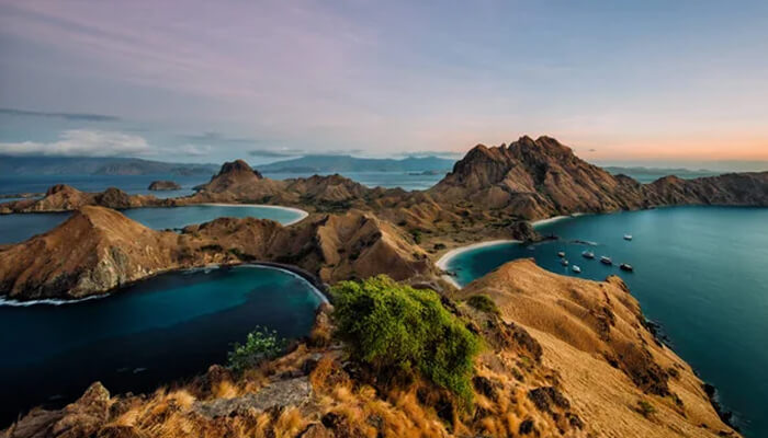 A breathtaking view of Padar Island in Komodo National Park, Indonesia, with rugged hills and turquoise waters creating a stunning contrast at sunrise.
