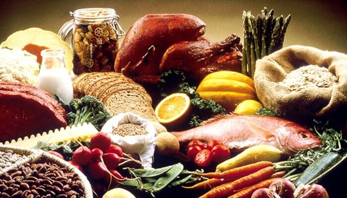 A variety of high calorie foods including meats, grains, vegetables, fruits, nuts, and dairy arranged together as a nutritious food display