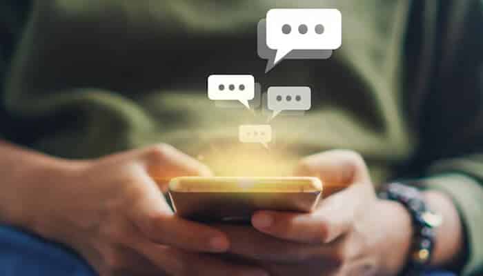 Gen Z phrases used in social media and on the internet - Food Fun Trip - FoodFunTrip Close-up of a person holding a smartphone with chat bubbles appearing above, symbolizing texting and communication commonly used in Gen Z slang