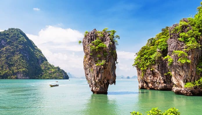 Iconic limestone rock formation at James Bond Island, Thailand, towering above calm turquoise waters, showcasing the natural beauty of the bay