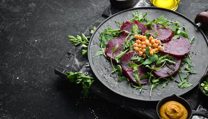Roasted Beet Arugula Salad - Food Fun Trip - FoodFunTrip A healthy beetroot salad with arugula, chickpeas, and a drizzle of dressing, offering a nutritious and colorful option