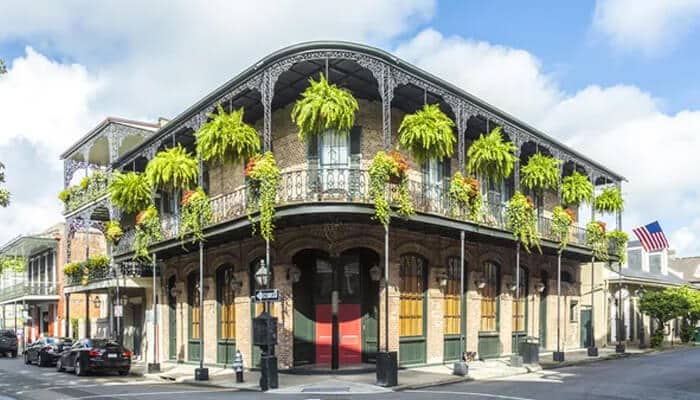 The French Quarter Things To Do While Visiting New Orleans - Food Fun Trip - FoodFunTrip A charming French Quarter building in New Orleans, showcasing one of the iconic things to do in New Orleans with its historical architecture and vibrant greenery