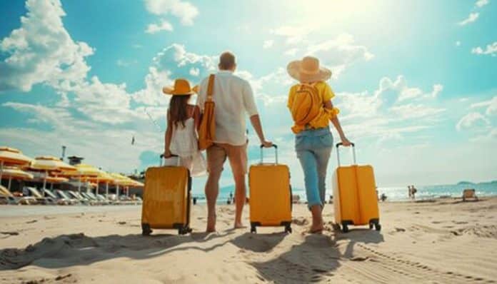 Family travelers walking on a sunny beach with suitcases while planning their getaway with Vacations to Go