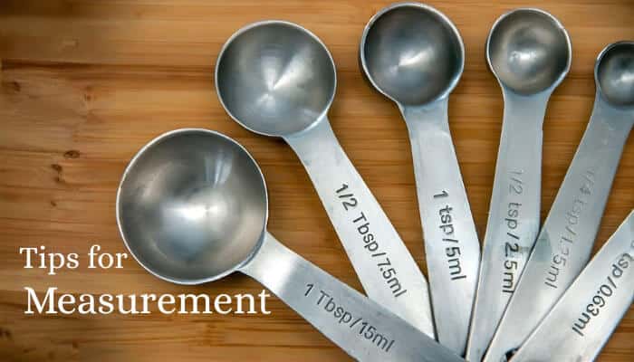 How Many Tablespoons are in 1/4 Cup- Foodfuntrip - FoodFunTrip How Many Tablespoons are in 1/4 Cup" – A collection of silver tablespoons arranged on a wooden surface, illustrating the 1/4 cup conversion for easy measurement in cooking