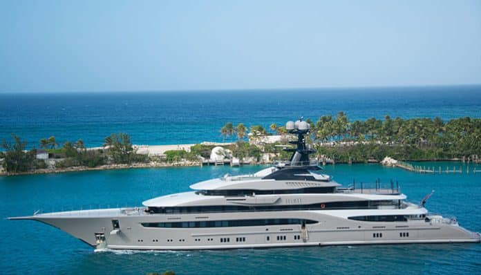 Caribbean Yacht Rentals superyacht cruising near a tropical island with calm blue sea and luxury coastal views.