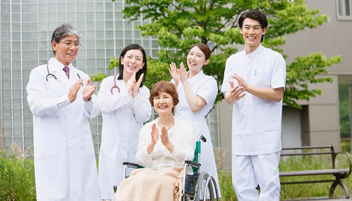 Common Techniques Used by Healthcare Providers - Food Fun Trip - FoodFunTrip Mechanical Debridement recovery support with healthcare team assisting elderly patient in wheelchair, highlighting advanced wound care, chronic ulcer management, post-treatment rehabilitation, and improved healing outcomes in a medical setting.
