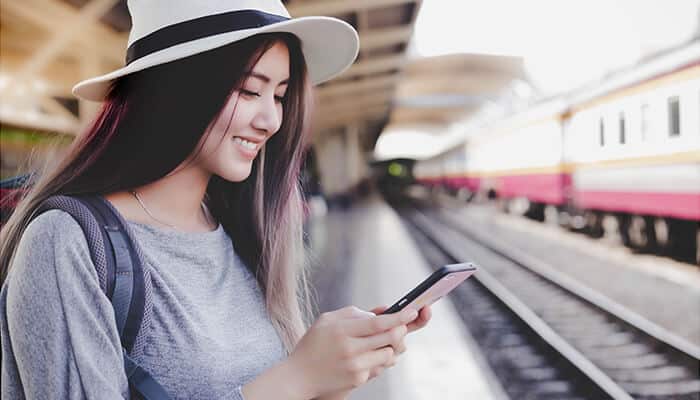 How Automated Monitoring Changes Everything - Food Fun Trip - FoodFunTrip Good Travel Tool helping a traveler monitor real-time train and flight award availability, mobile booking alerts, route updates, and smart travel planning at a modern transit station.