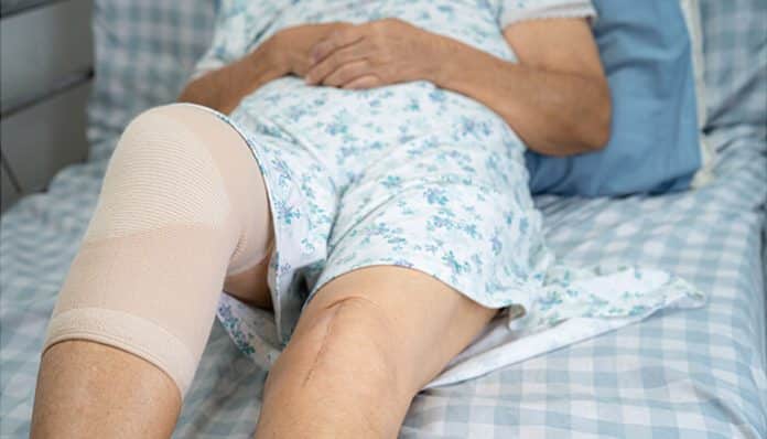 Mechanical Debridement treatment for chronic leg wound patient in hospital bed, showing advanced wound care management, compression therapy, infection prevention, and tissue healing support for stubborn lower limb ulcers.