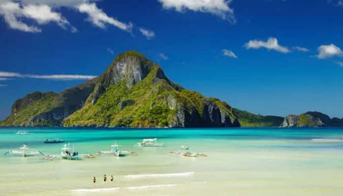 Plan an Unforgettable Trip to the Philippines with crystal-clear turquoise waters, limestone islands, tropical beaches, and traditional boats in El Nido Palawan.