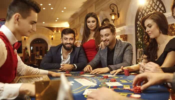 Maximizing Your Casino Experience - Food Fun Trip - FoodFunTrip Group of people enjoying a casino game in a luxury Las Vegas casino, with cards, chips, and excitement — ideal visual for planning a Las Vegas Trip.