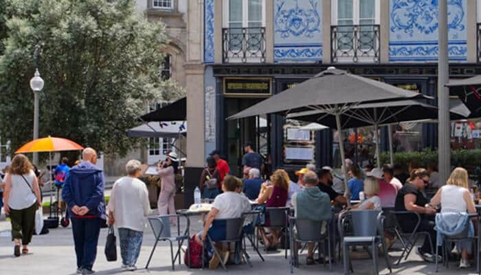 What Makes the Food So Special Here - Food Fun Trip - FoodFunTrip Cycling travelers enjoying a Portuguese food and culture experience with local cafés, traditional architecture, and community atmosphere during a cultural cycling tour in Portugal.