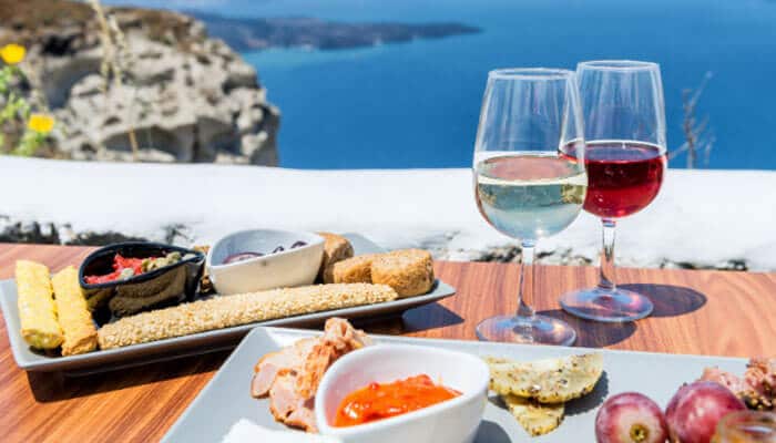 Drink the island - Food Fun Trip - FoodFunTrip Hvar food and wine experience overlooking the Adriatic Sea, featuring local dishes with glasses of red and white wine on a scenic coastal terrace.