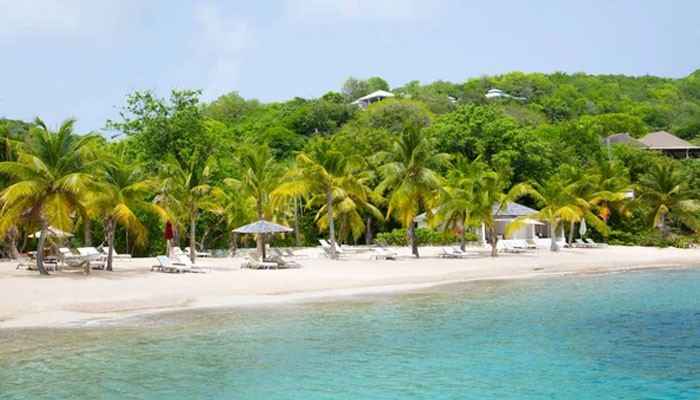 A Practical Five-Day Virgin Islands Itinerary - Food Fun Trip - FoodFunTrip Virgin Islands tropical coastline featuring a peaceful beach resort view, palm trees, crystal-clear Caribbean waters, white sandy shore, and lush green island landscape for a relaxing vacation itinerary.
