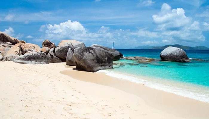 Best Time to Visit the Virgin Islands - Food Fun Trip - FoodFunTrip Virgin Islands beach landscape featuring crystal-clear turquoise Caribbean waters, white sandy shoreline, natural granite rocks, and a tropical coastal paradise view.