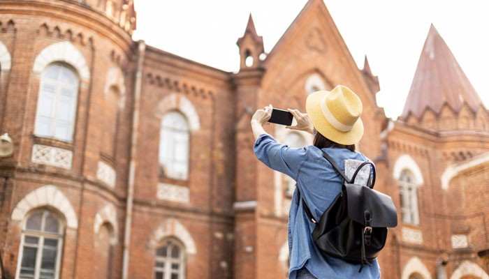 Budgeting for Your Trip - Food Fun Trip - FoodFunTrip Barcelona Travel Guide showing a tourist capturing historic European architecture during a city visit, highlighting cultural sightseeing, travel experiences, and Barcelona’s iconic landmarks in Spain