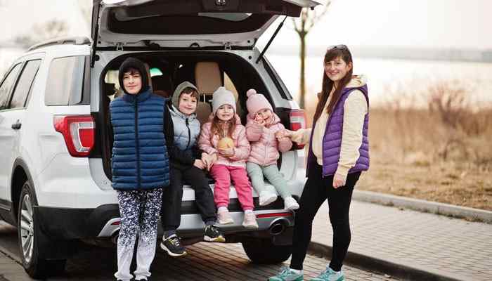 Family Car Travel Tips for a Comfortable Journey - Food Fun Trip - FoodFunTrip Car Travel With PaxTravelTweaks family road trip showing a parent and children beside an SUV, highlighting passenger comfort, trip preparation, rest stops, and child travel safety.