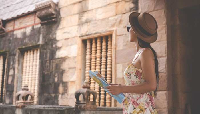 Can Americans Visit Cuba Without a Tour Group - Food Fun Trip - FoodFunTrip Can Americans Travel to Cuba independently? Female traveler holding a map while exploring historic architecture, representing authorized Cuba travel and U.S. travel requirements.