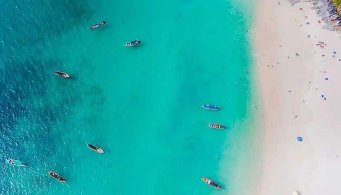 Crash Boat Beach Aguadilla For a Lively Atmosphere - Food Fun Trip - FoodFunTrip Aerial view of Crash Boat Beach in Aguadilla, one of the popular Beaches in Puerto Rico, featuring turquoise water, a sandy shoreline, small boats, and visitors enjoying the coast.