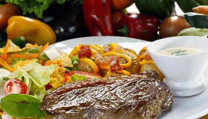 Texas Roadhouse Family Meals and Takeout Prices - Food Fun Trip - FoodFunTrip Texas Roadhouse Menu With Prices featuring a grilled steak served with fresh garden salad, colorful vegetables, pasta, and creamy dipping sauce.